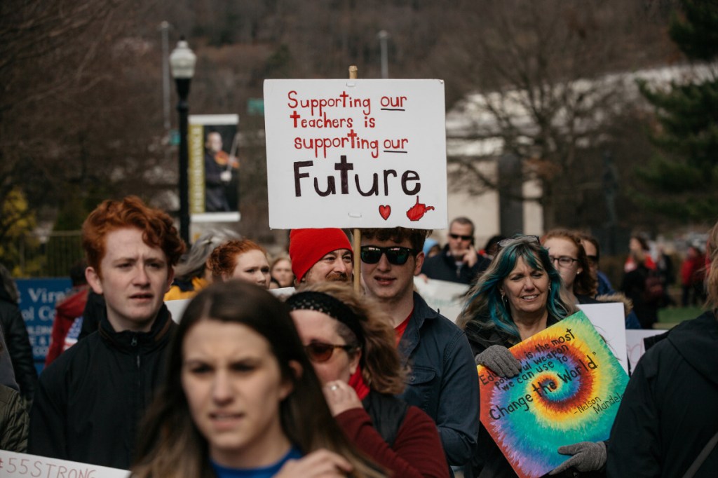 Teachers and demonstrators hold signs during a rally outside the West Virginia Capitol in Charleston on March 2.