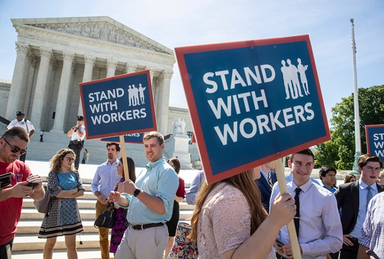 People gather on Monday at the Supreme Court awaiting a decision in an Illinois union dues case, Janus vs. AFSCME.