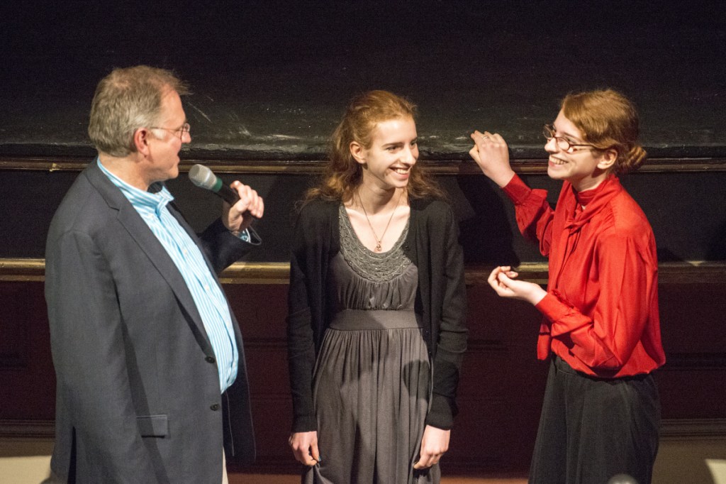 Maine Public education program director Dave Boardman presents Isabelle Rogers, center, and her twin sister, Phoebe, with the Maine Public Grand Prize for their short film "Searching for Spring" at the 41st annual Maine Student Film & Video Festival awards ceremony on Saturday at the Waterville Opera House.