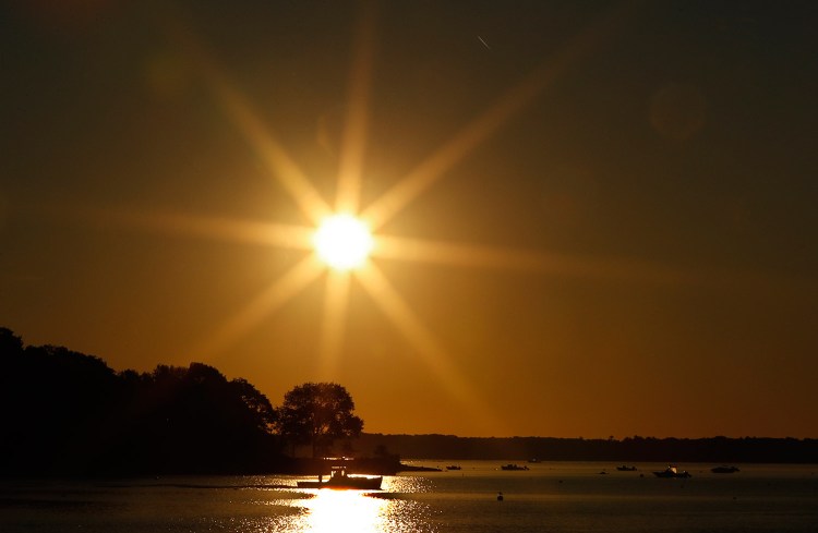 A lobster fishing boat motors out of the Harraseeket River under a dazzling sun this month in Freeport. The lobster season is in the midst of its busiest time of the year.