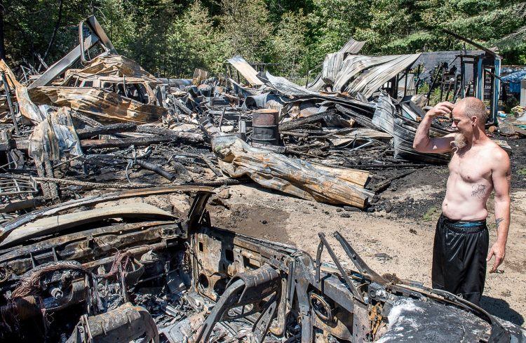 Travis Cummings looks at what was once a three-bay garage where he works on friends' vehicles. He was restoring an '88 Oldsmobile where his father, Nelson Cummings, who owns the property, once operated a car repair business.