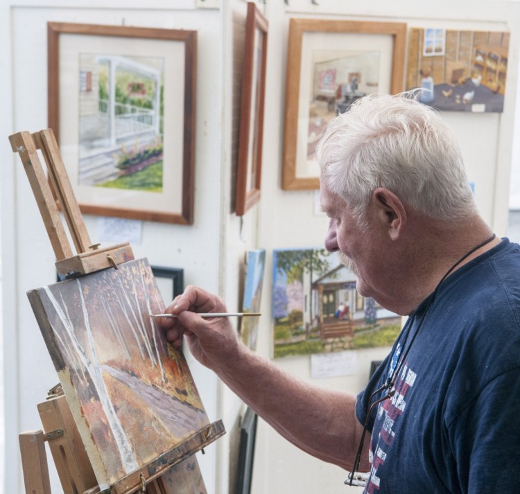 Jim Decker of Richmond adds refinements to "A Walk in the Maine Woods," an acrylic work showing birch trees hangng on to their leaves in autumn. All his art has a story, Decker says.