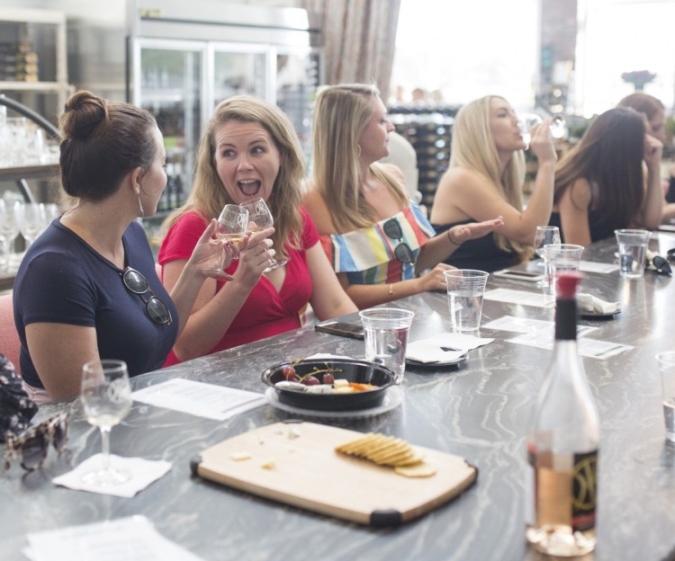 Bride-to-be Katie Dooley, left, clinks a glass with her friend Brittany Walsh at Cellardoor Winery during a bachelorette party weekend in Portland recently. Cellardoor welcomes not only the business from party-of-12 tasting events like these, but also the social-media buzz it generates.