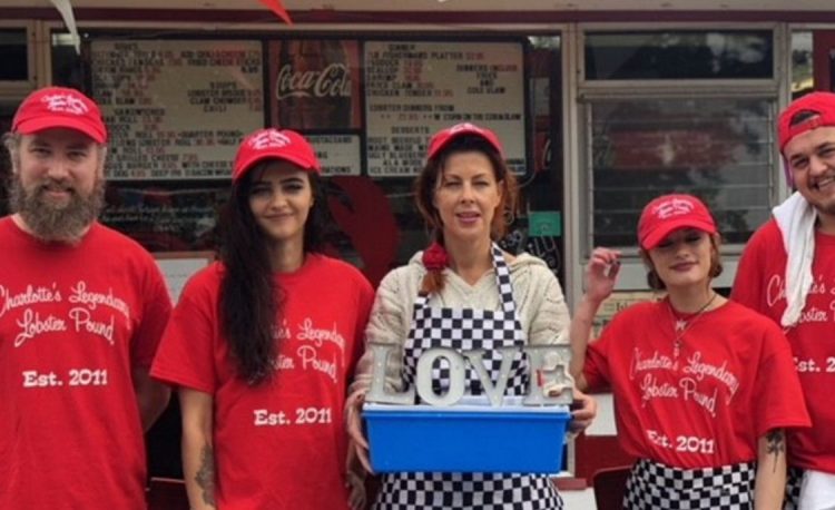 Charlotte Gill, center, holds the plastic container where she experiments with exposing lobsters to marijuana in hopes of giving them a more humane death.