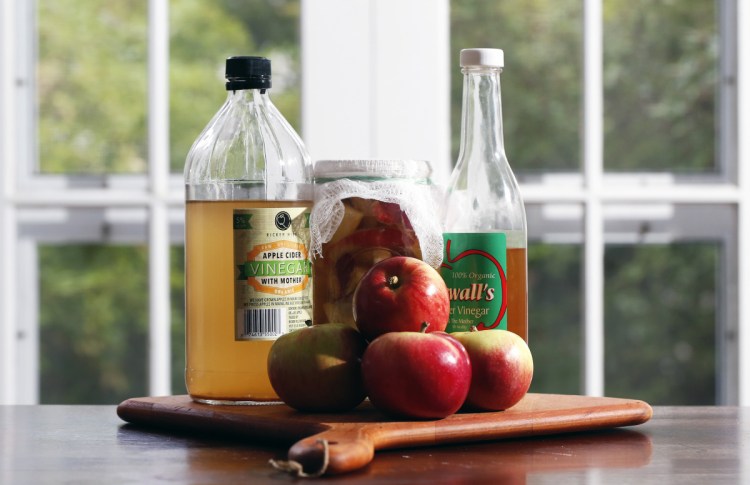 Maine apple vinegars made by Harry Ricker of Ricker Hill Orchards in Turner (left), and Bob Sewall of Sewall Orchard in Lincolnville (right) with a homemade vinegar brewing in a jar (center).