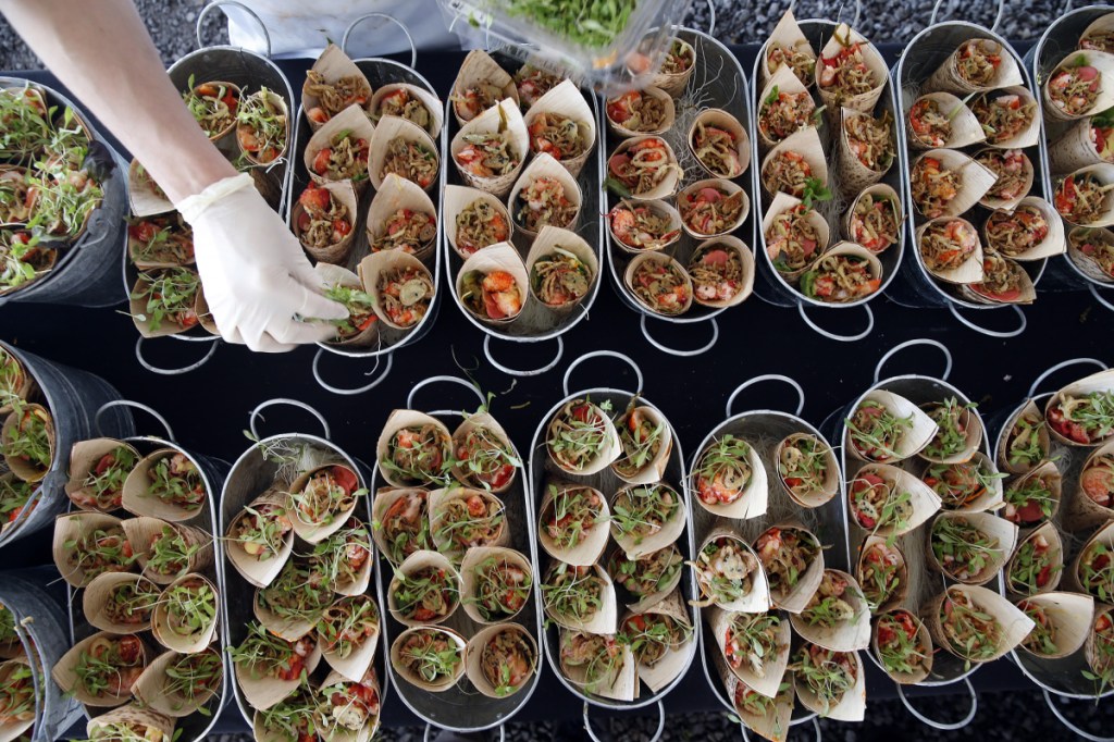 Andy Negus, sous chef of The Black Tie Co., adds petite cilantro to lobster seaweed salad cones. The dish's creator – Avery Richter – executive chef of The Black Tie Co. – would go on to win the Harvest on the Harbor Lobster Chef of the Year contest.