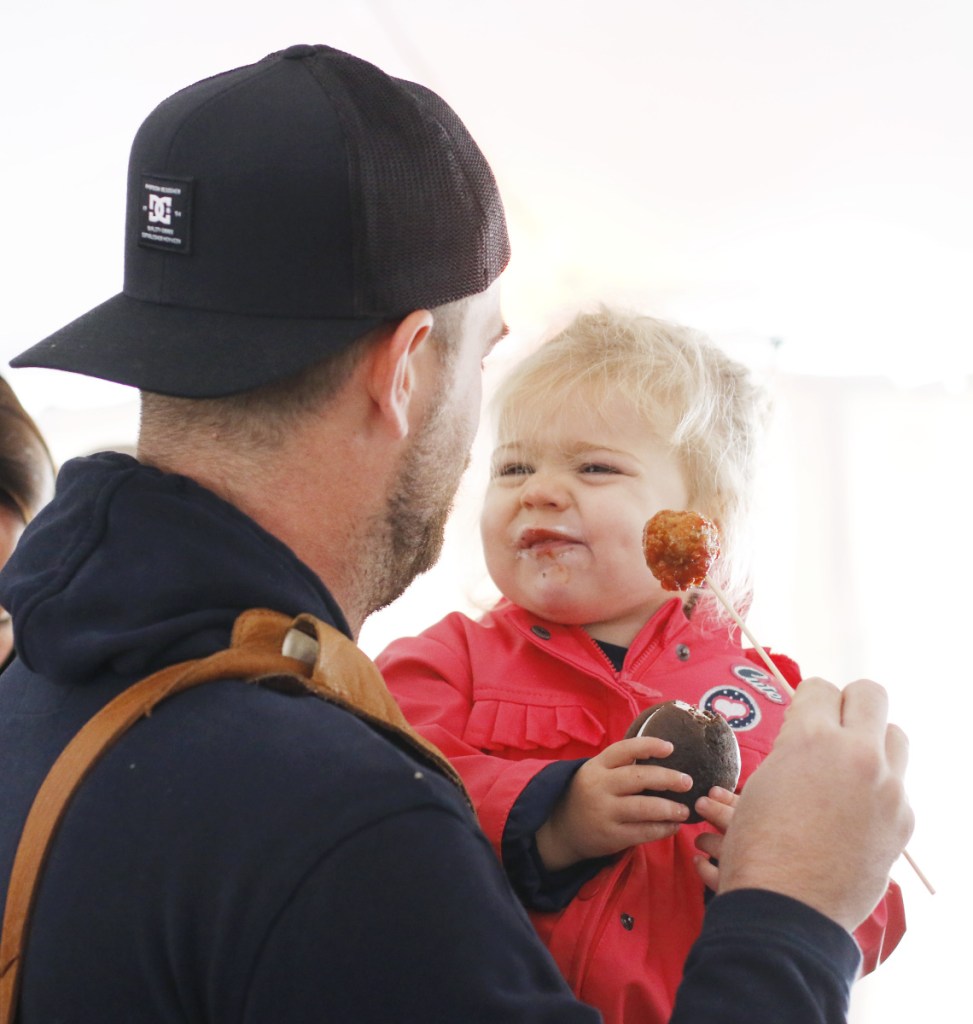 Coline Magloire La Greve, 21 months, of Normandy, France, reacts Sunday after tasting a Ricetta's meatball while visiting the Market on the Harbor with her father, Jean Baptiste Magloire La Greve.