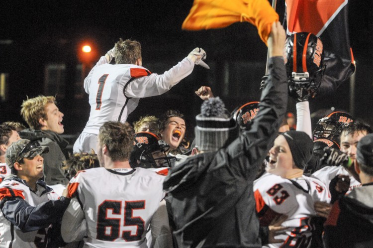 Staff photo by Joe Phelan
Brunswick players celebrate their 21-13 win over Cony in a Class B North semifinal Friday night in Lewiston.