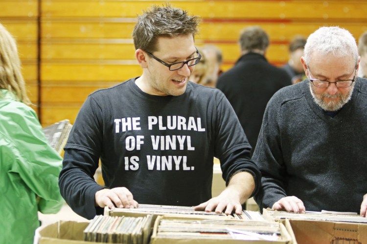 Hundreds of vinyl enthusiasts, including Brian Lozo of Biddeford and Jonathan Gilbert of Portland, seek out hidden gems Saturday at the WMPG Record Sale at the University of Southern Maine's Sullivan gym. 