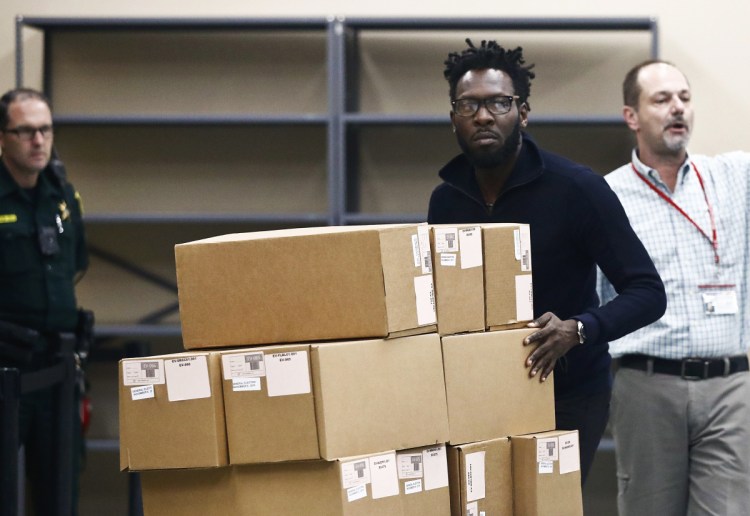 Elections officials move ballot boxes to be counted at the Broward County supervisor of elections office during a recount on Sunday in Lauderhill, Florida. 