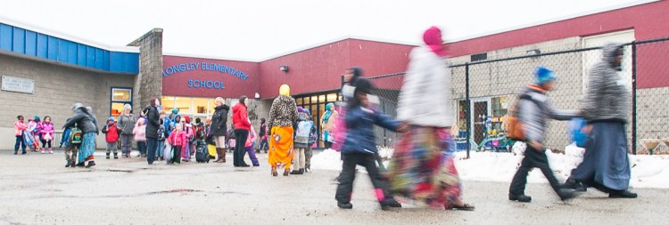 Parents walk their children from Longley Elementary School in Lewiston on Monday. The district was bracing for another possible snow day Tuesday.