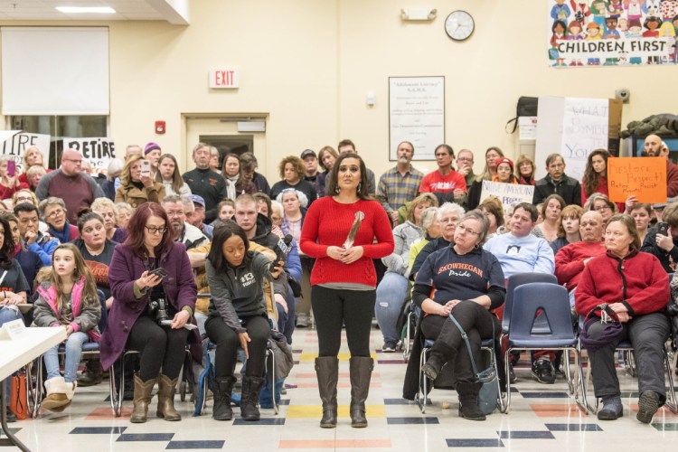 Maulian Dana, the Penobscot Nation's tribal ambassador, gives a speech Thursday as she holds an eagle feather as an example of what a symbol is, as the two sides of the "Indians" mascot battle converge at a school board meeting at Skowhegan Middle School. The Penobscot Nation Youth Council joined with local students to protest continued use of the mascot.