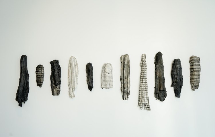 Erin Woodbrey, "Fragments," India ink on fired porcelain formed from fabric and wood.