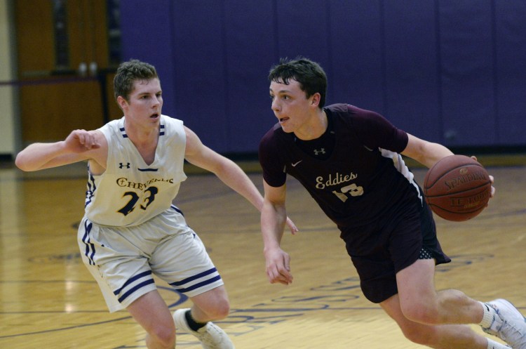 Edward Little's Cam Yorke drives against Nolan Sanborn of Cheverus during their Class AA North boys' basketball game Friday night in Portland. Edward Little won, 61-56.