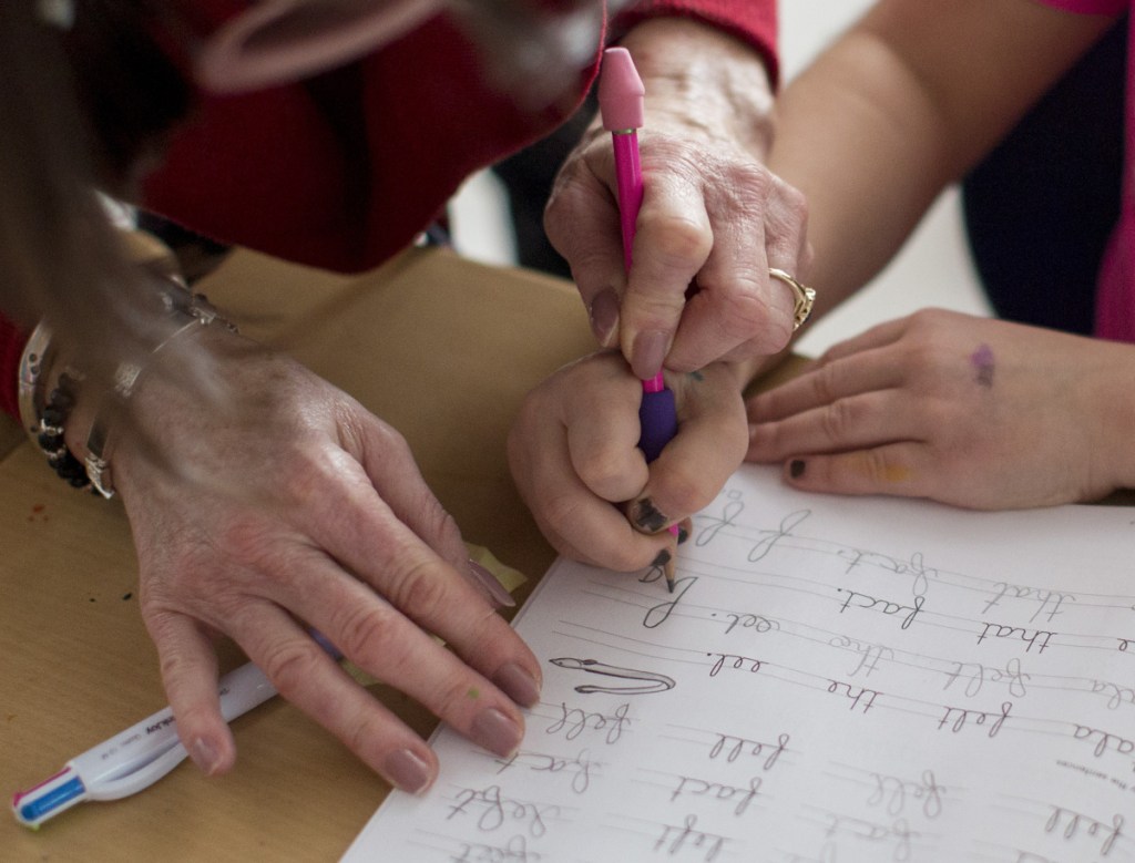 Gorham schoolteacher Tracy Burns offers one student a helping hand. Fourteen states require instruction in cursive, but Maine isn't among them.