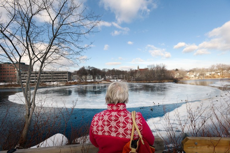 Pat Mahoney of Gorham checks out the giant disk of ice on the Presumpscot River in Westbrook on Wednesday, even though it had lodged against the riverbank and stopped spinning.