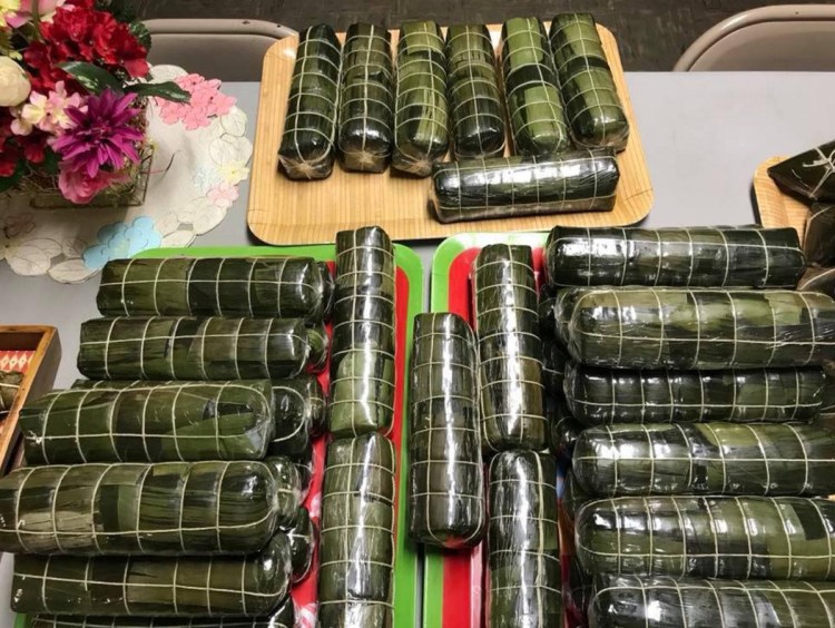 Banh tet, wrapped in banana leaves, is ready to be unwrapped, sliced and served. The vegan filling is made of sticky rice and mung beans.