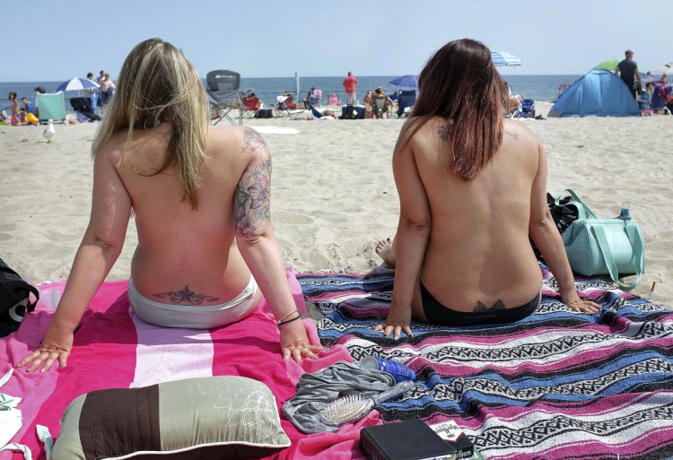 Women go topless in August 2017 as they participate in the Free the Nipple global movement during Go Topless Day at Hampton Beach, N.H. New Hampshire's highest court has ruled that an anti-nudity ordinance in Laconia does not discriminate on the basis of gender or violate women's right to free speech.