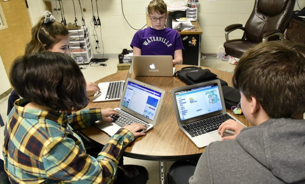 Morning Sentinel photo by David Leaming 
 Waterville Junior High School students, clockwise from lower left, Alexa DeWitt, Leilani Gomez, Zachary London and Dylan Mitchell, work on assignments with computers Thursday. When they move up to Waterville Senior High School, they will have the opportunity to participate in a unique computer science pilot program funded by an $881,000 grant from the Harold Alfond Foundation.