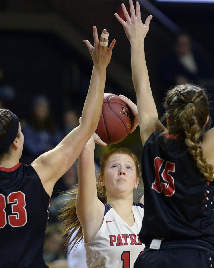 Gray-New Gloucester's Eliza Hotham takes a shot as Grace Ramsdell, left, and Franny Ramsdell move in on defense for Wells 