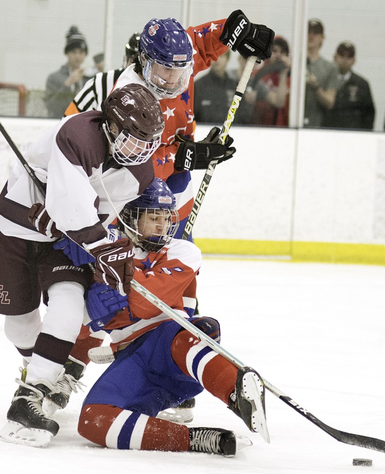 Jack Keefe, left, of Edward Little, battles with Cade Charron, back, and Noah Magda of the Mt. Ararat during Tuesday's game in Auburn. Keefe scored in overtime and the Eddies won, 2-1.