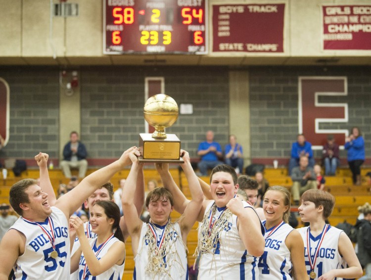 Madison's Scott Sawtelle hoists the Gold Ball with his teammates after they dethroned Westbrook 58-54 for the Unified title Tuesday. Unified basketball pairs students with and without disabilities, building ties that last off the court.