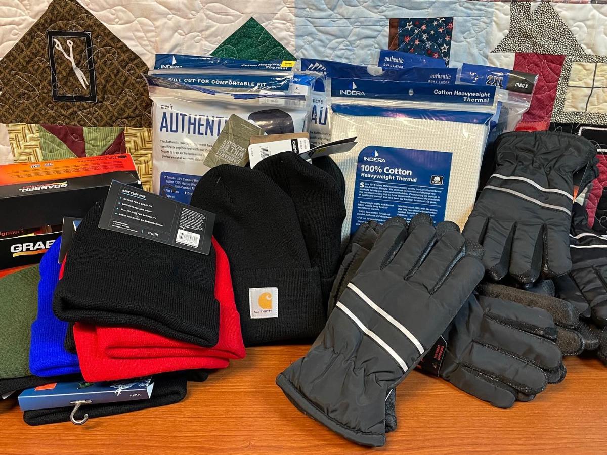 A pile of winter donations to Milestone Recovery residents including hats, gloves and long underwear.