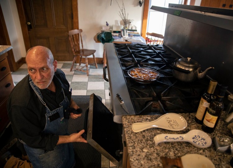 Brother Arnold pulls  plum kuchen out of the oven in the kitchen at the Shaker Village in early December.