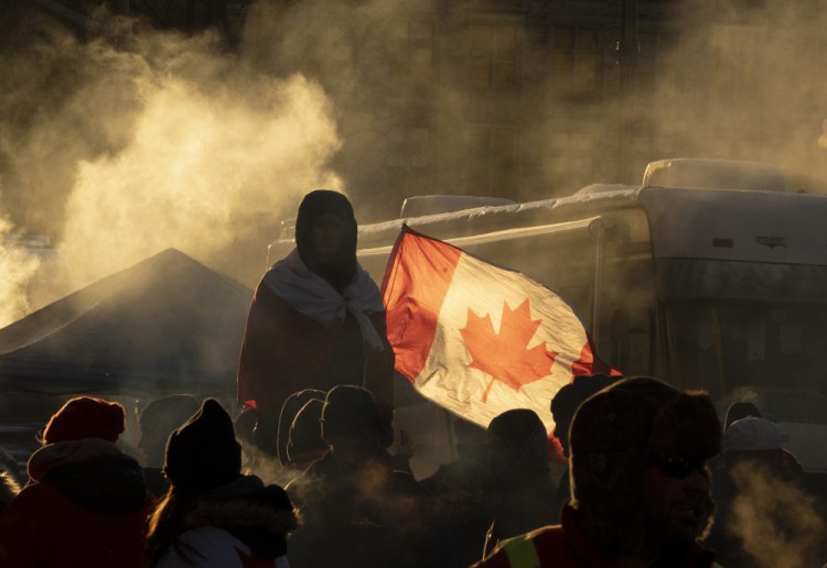 A protester stands on a barricade as trucks continue to block the downtown core in protest Saturday of COVID-19 restrictions, in Ottawa, Ontario.