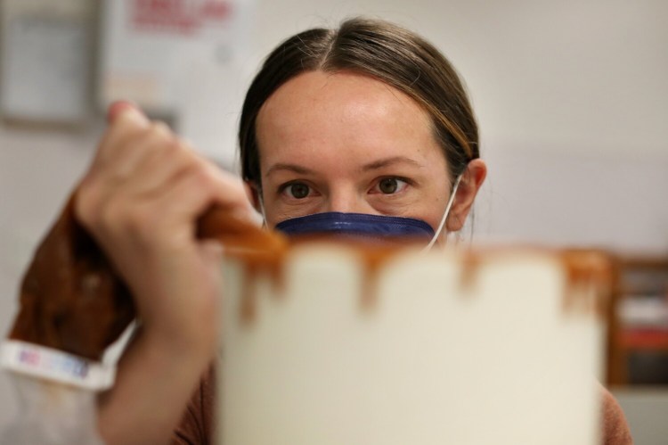 Elizabeth Rzoska, baker and owner of Prairie Baking Co. in Portland, uses caramel to decorate a cake.