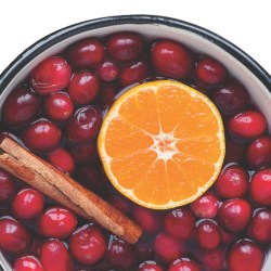 A stovetop potpourri blend of cranberries, cinnamon sticks, and an orange