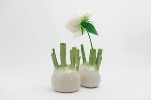 Two ceramic vases sculpted to look like fennel bulbs. One has a peony in it.